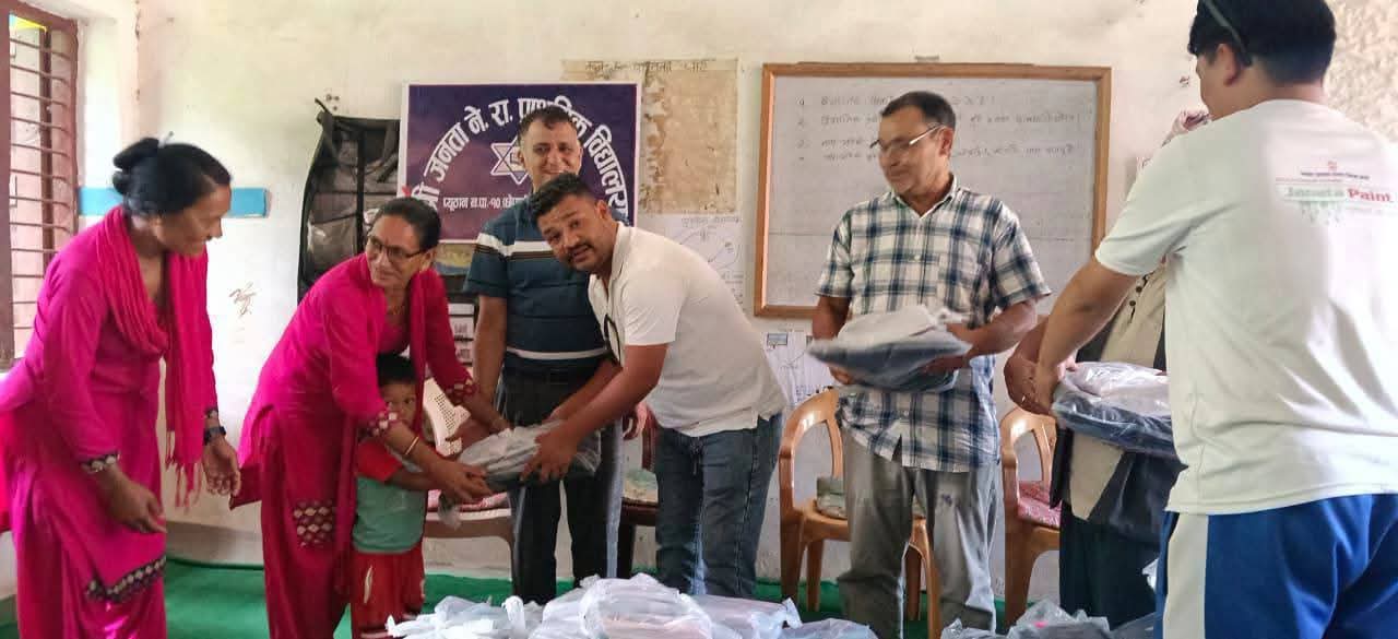 नेराप्राबी छेपानेमा एक सहयोगीद्वारा विद्यार्थीलाई शैक्षिक सामग्री हस्तान्तरण